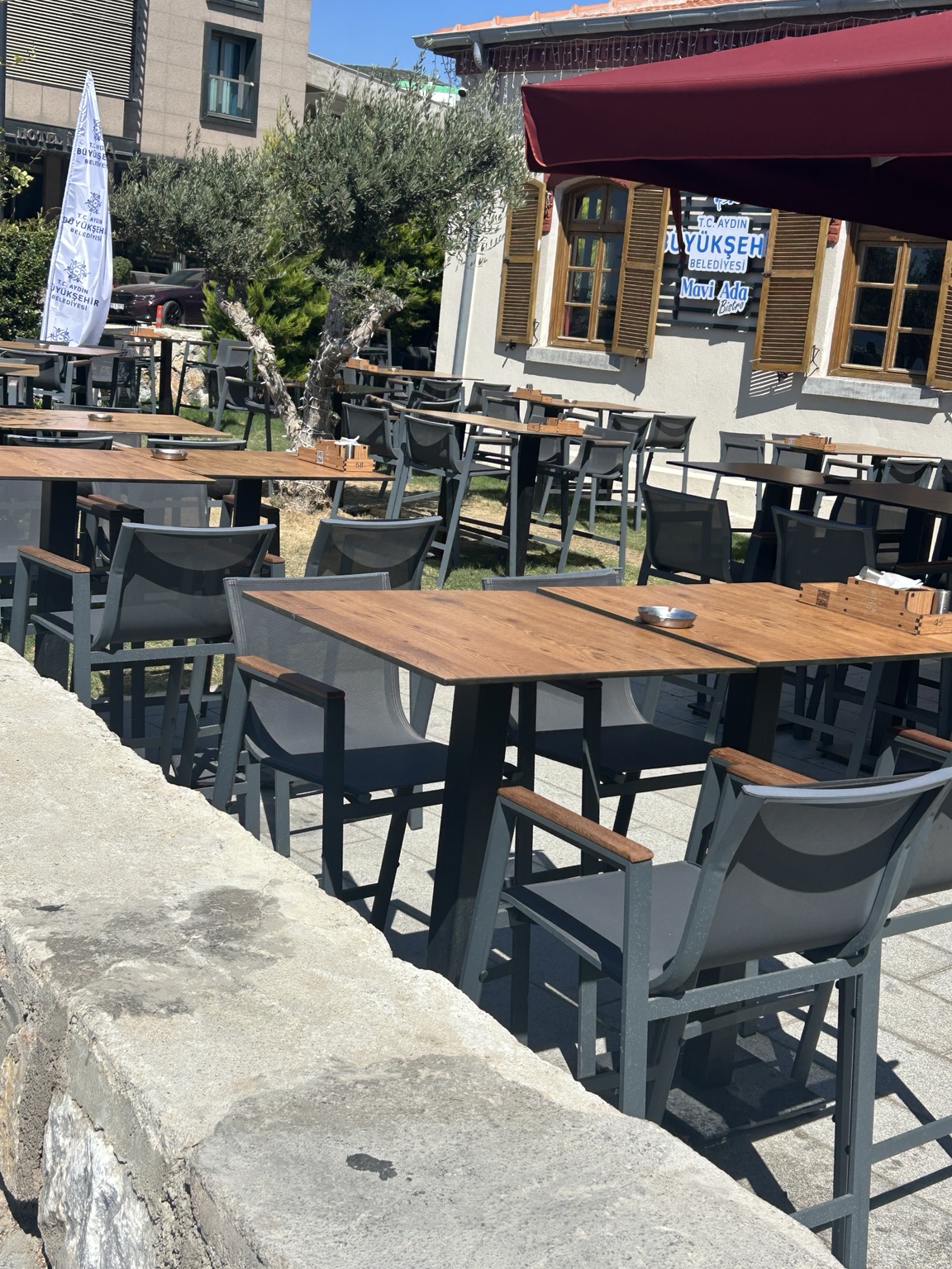 Kafe bahçesindeki kompakt masa tablalarıyla oluşturulan oturma düzeni