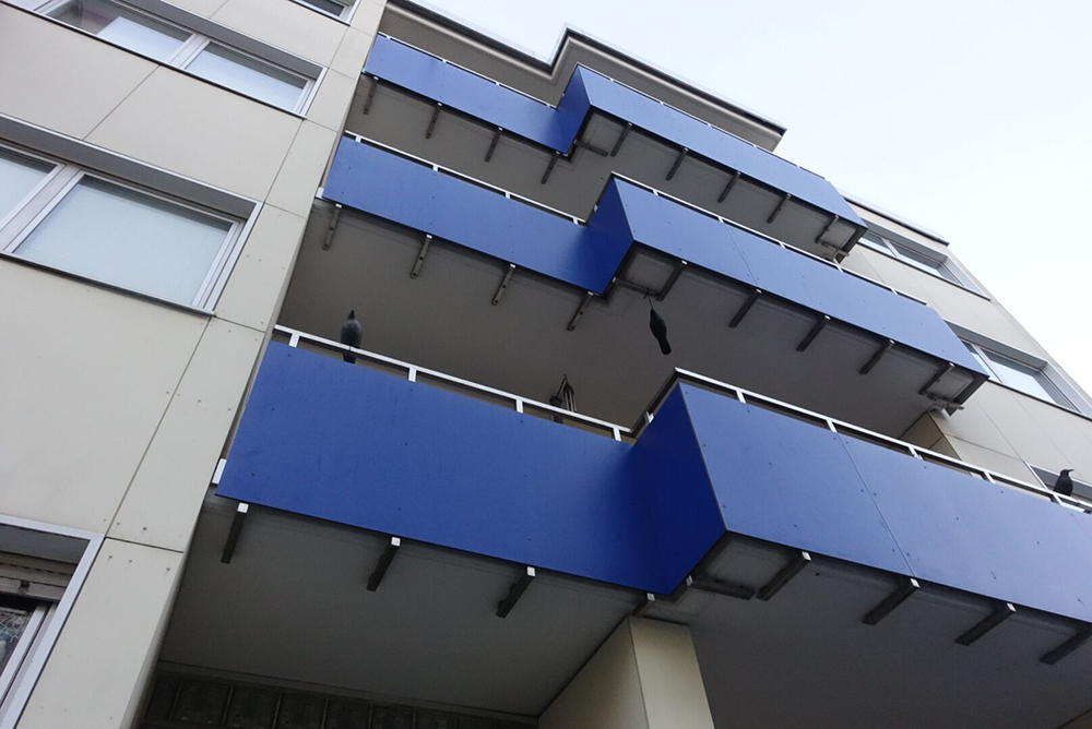Mavi panellerle kaplanmış balkon ve dış cephe görünümü